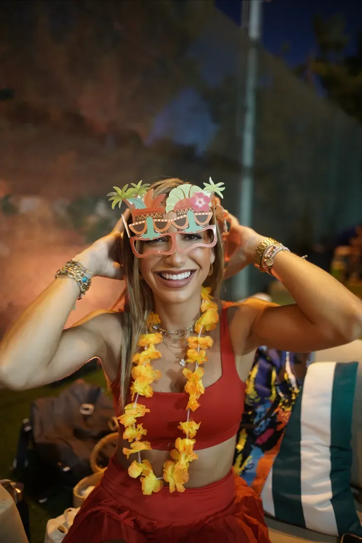 A smiling guest wearing tropical party glasses