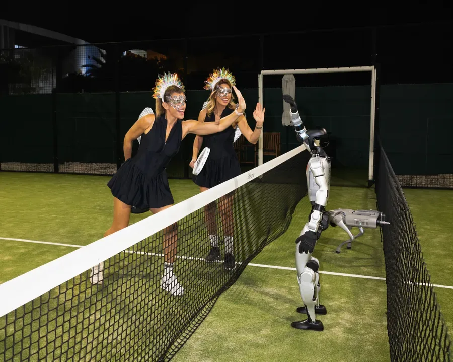 Players greeting a robot across the padel net